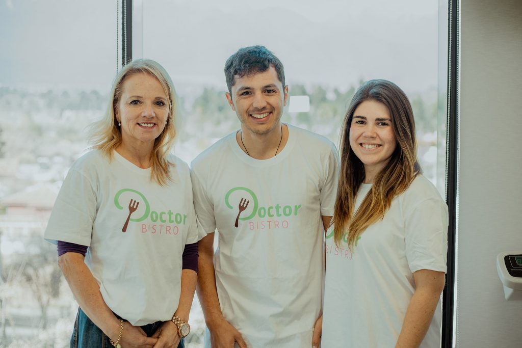 equipo doctor bistro dos mujeres y un hombre en medio con camisetas con logotipo