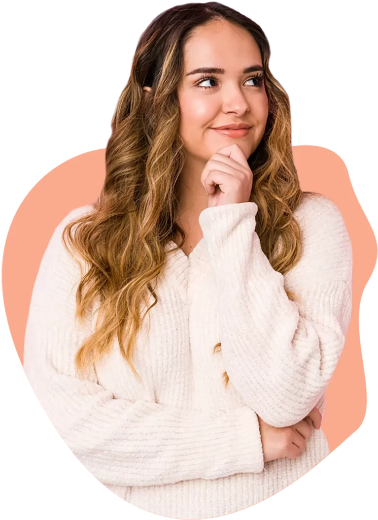 mujer joven de pelo castaño y chaleco de lana pensando con su mano en la barbilla